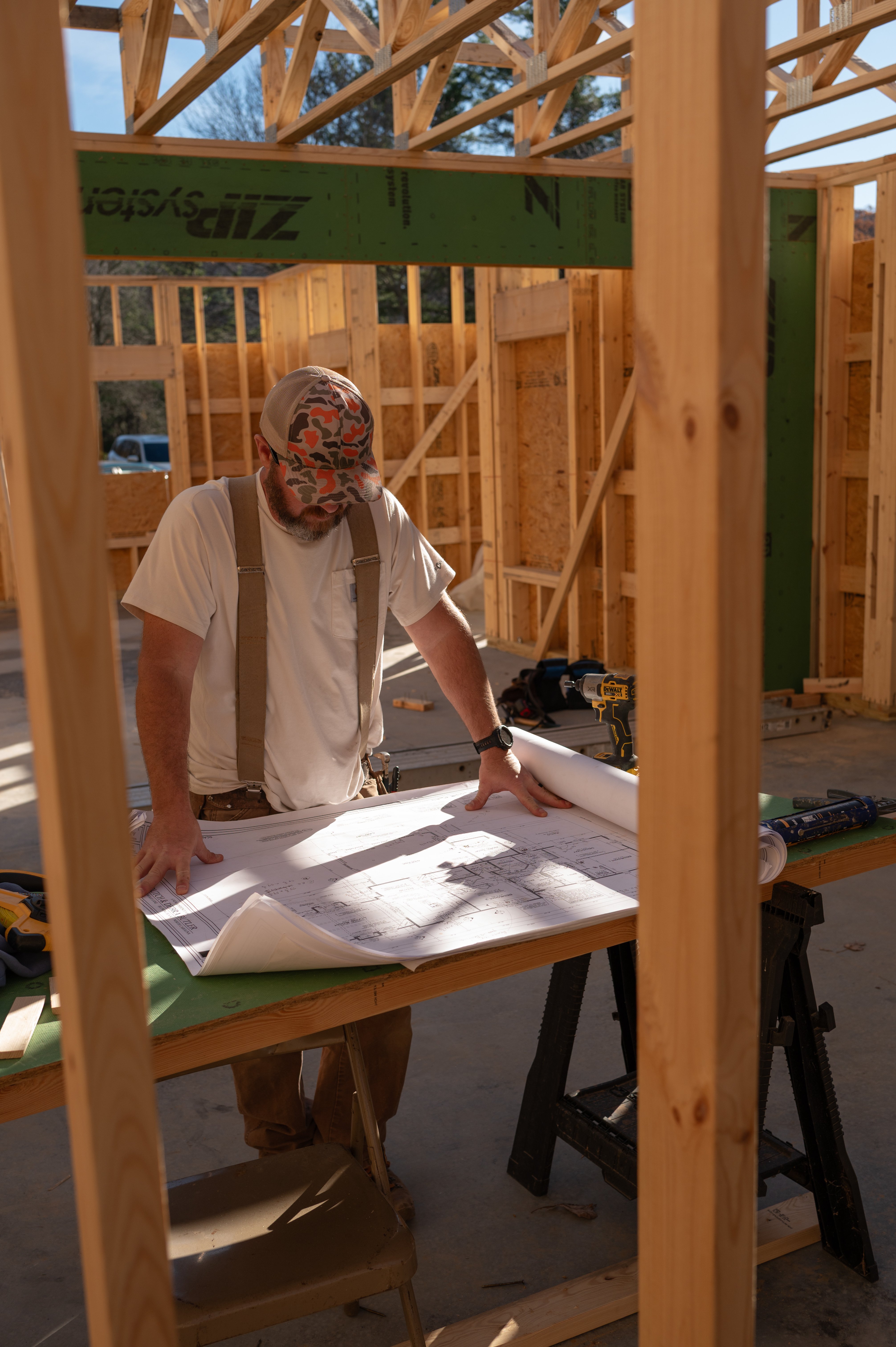 Adam Greene reviewing blueprints on an ARCH Home Crafters job site