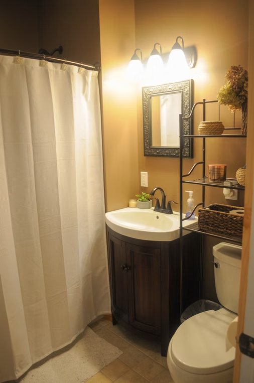 Custom bathroom with dark wood vanity, framed mirror, and tiled floor