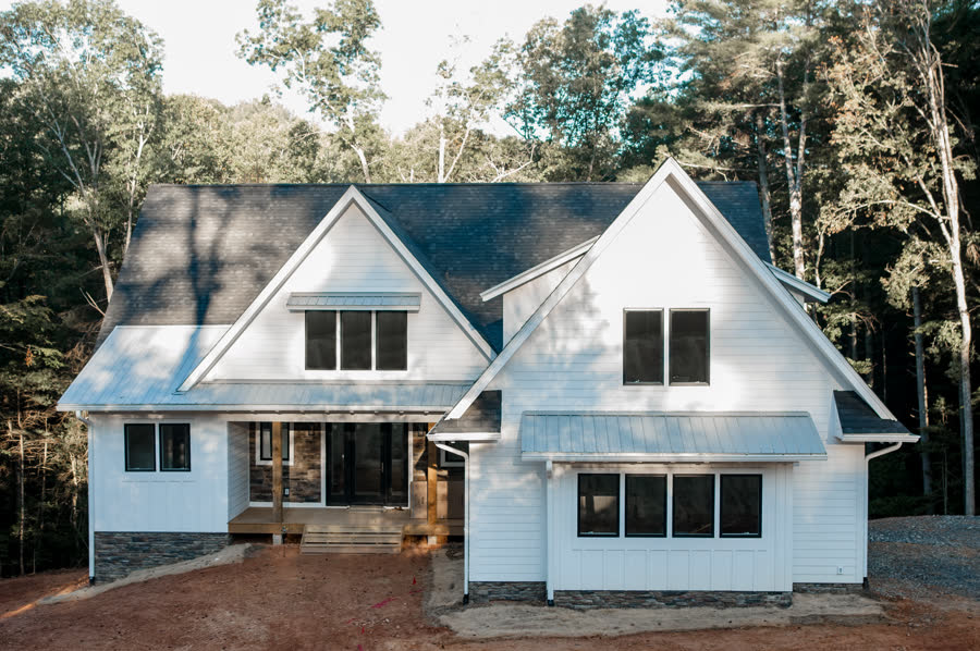 Custom white board-and-batten farmhouse exterior built by ARCH Home Crafters
