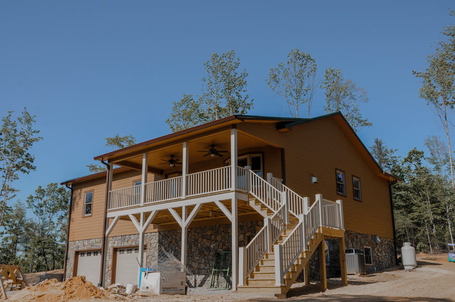 Wraparound Porch Home exterior with stone foundation, wraparound porch and metal roof