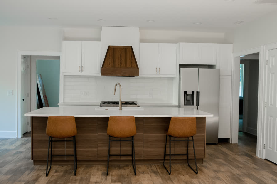 Renovated white kitchen with a custom wood range hood